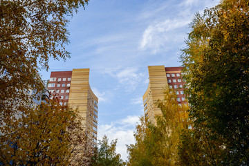 Two towers of an apartment house behind trees