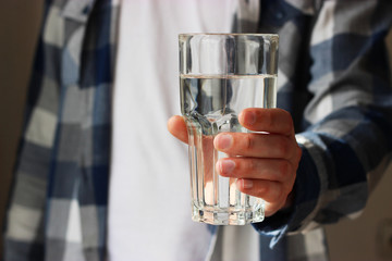  the man is holding a large glass of water in his hand. use of water. body care, health, diet. 