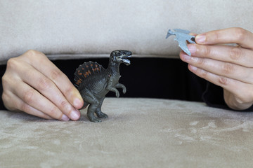 play with dinosaurs in the school. dinosaur and hand on the ground for children activities.