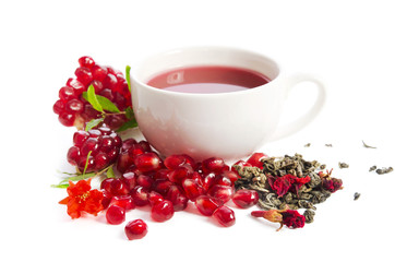 Parts of a pomegranate with pomegranate seeds and leaves, flowers, dry tea of carcade and full cup of tea isolated on white background