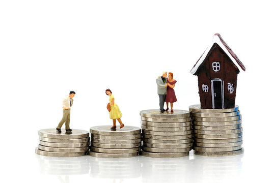 Miniature people : Couple of love with Stack of coins and mini house,Business finance, saving and home loan mortgage concept.