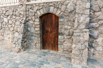 Fototapeta na wymiar Ancient wooden door in the wall, brown. Texture