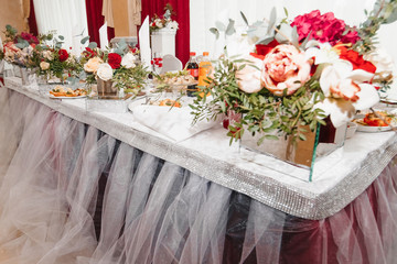 Classic and elegant wedding presidium and tables decor with blue cloth and bright blue and green flowers