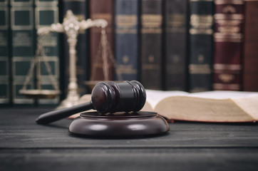 Judge Gavel , Law books and Scales of Justice on a black wooden background.