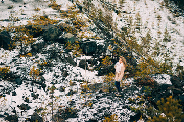 girl in autumn among the wildlife of the North, rocks and cliffs, the concept of traveling to wild places