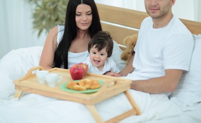 Obraz na płótnie Canvas Family having breakfast in bed at home