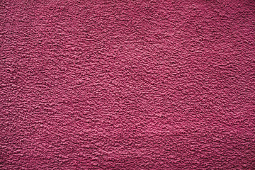 Pink rough wall close-up. Background image of magenta uneven wall.