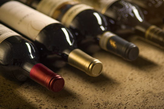Set of red dry wine bottles on cork background. Low depth of field. 