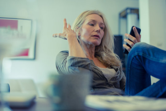 Mature woman using smartphone at home