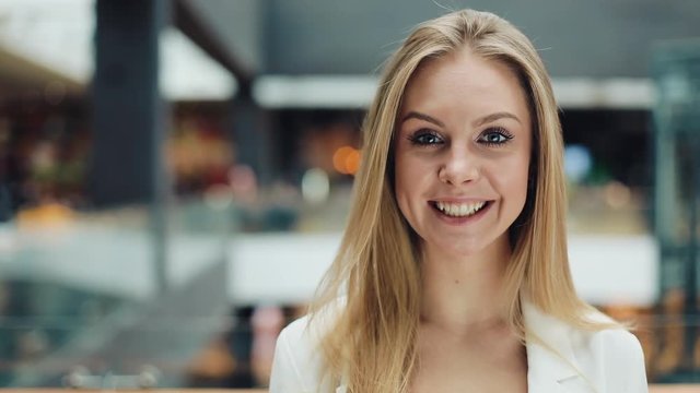Attractive young woman look ar camera smiling feel happy in mall close up shopaholic fashion clothing girl shopping money lifestyle store portrait weekend shop slow motion