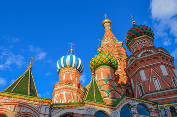 Fototapeta na wymiar Domes of St. Basil Blazhenny's temple in blue sky, famous landmark on the Red Square in Moscow, Russian symbol