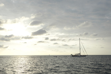 cloudy sky and sunset with boat sailing through on the ocean in the nice day