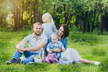 Family with two children rest in the summer garden