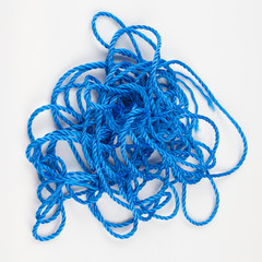 Tangled blue rope on white background