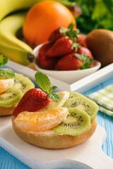 Healthy breakfast fruits and ricotta sandwiches- with strawberries, kiwi and orange.