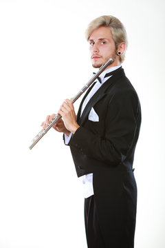 Male flutist wearing tailcoat holds flute