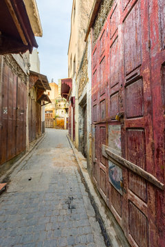 Old street with red door in Fes medina