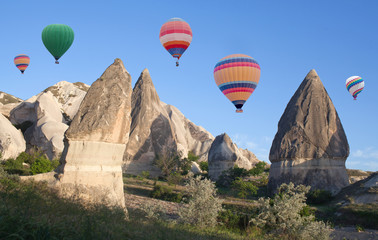 Fototapeta na wymiar Unique geological formations and colorful hot air balloons flying over Cappadocia, Anatolia, Turkey