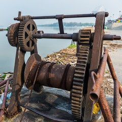 Naklejka premium Belgrade, Serbia April 07, 2018: The Danube Coast in Zemun. Ship pulling machine and what remains on the shore when the water withdraws.