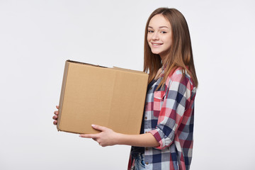Delivery, relocation and unpacking. Smiling young woman holding cardboard box isolated