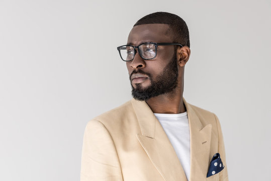 portrait of handsome stylish young african american man in eyeglasses looking away isolated on grey