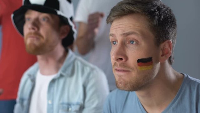 German supporters watching football match together, celebrating team victory