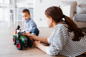 mom and son playing with plastic tractor