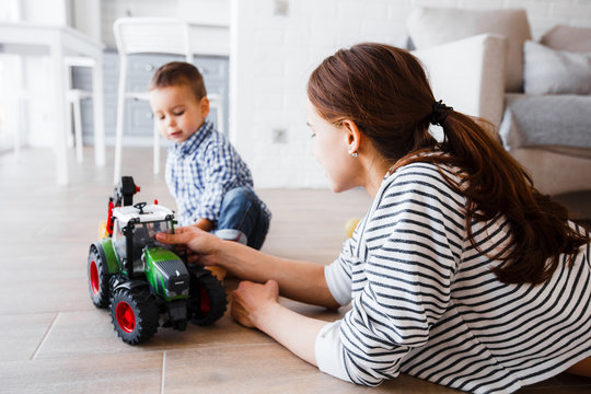 Mom And Son Playing With Plastic Tractor