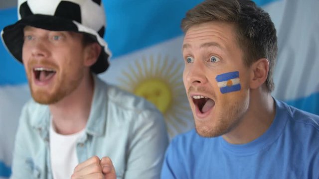 Argentina soccer fans watching football game on tv, celebrating team victory