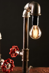 Black desk lamp made of water pipes and gauge pressure meter. 
