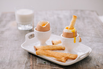 delicious breakfast with soft boiled eggs and crispy toasts, closeup