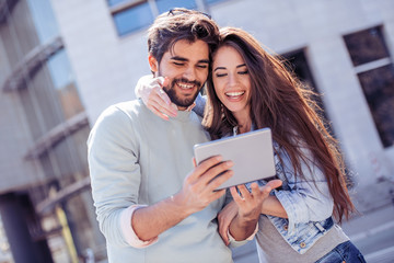 Couple using digital tablet outdoors