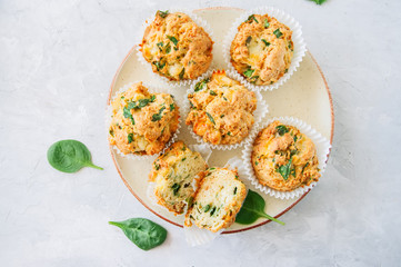 Savory potato spinach and feta muffins served on a plate. White stone background. Top view.