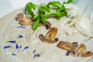Mushroom cream soup with black truffle in a ceramic white bowl