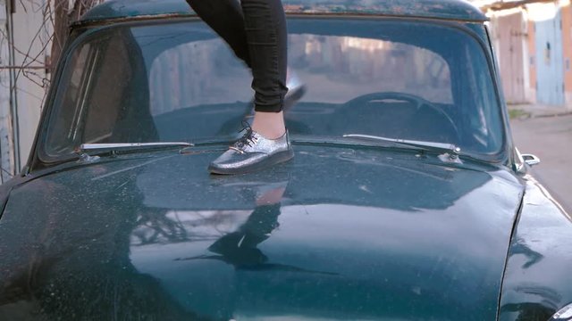 girl dancing on car hood. focus on the legs