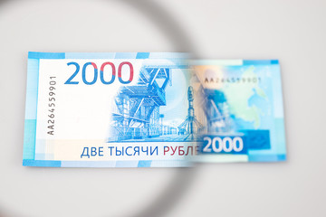 Two thousand roubles banknotes through a magnifying lens. Blurred background.