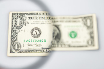 One  dollar banknote through a magnifying lens. Blurred background.