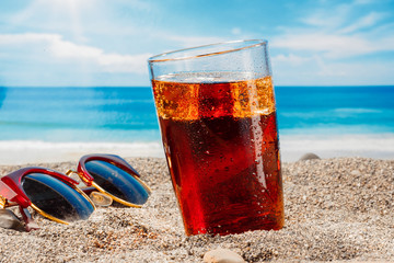 A cold drink in a glass on the beach, a delicious soft drink in the summer - 202467080