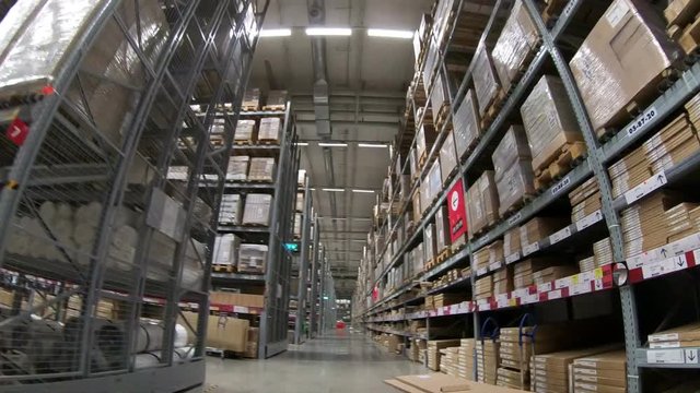 4K Time-Lapse of moving between palettes with cardboard boxes and different materials in a storage warehouse