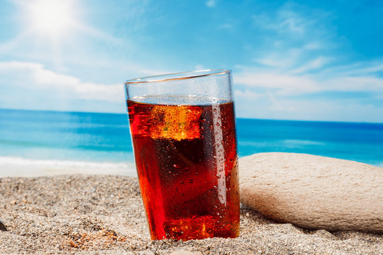 A cold drink in a glass on the beach, a delicious soft drink in the summer