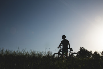Obraz na płótnie Canvas Silhouette of mountain biker in sunset 