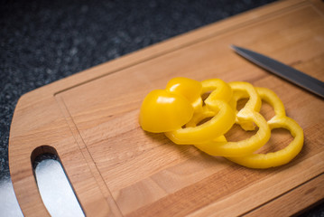 Yellow pepper on wooden board prepared for cooking