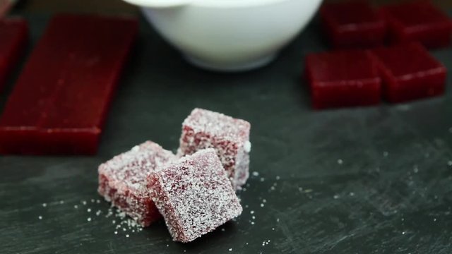 confectionery hand lays out crimson marmalade piece into group