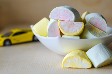 marshmallow with a multi-colored pattern in a cup on a light wooden background