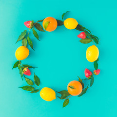 Creative summer layout made of lemons, oranges and strawberies on pastel blue background. Fruit minimal concept. Flat lay.