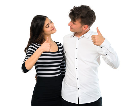 Young couple giving a thumbs up gesture and smiling on isolated white background