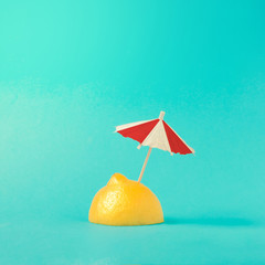 Tropical beach concept made of lemon and sun umbrella. Creative minimal summer idea.
