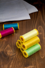 DIY concept multicolor Sewing thread and needle on white wooden background