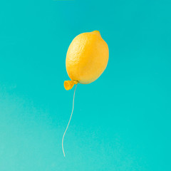 Lemon balloon on bright blue background. Minimal summer fun concept. - obrazy, fototapety, plakaty