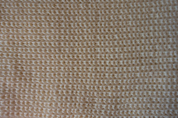Top view of beige handmade knitted fabric